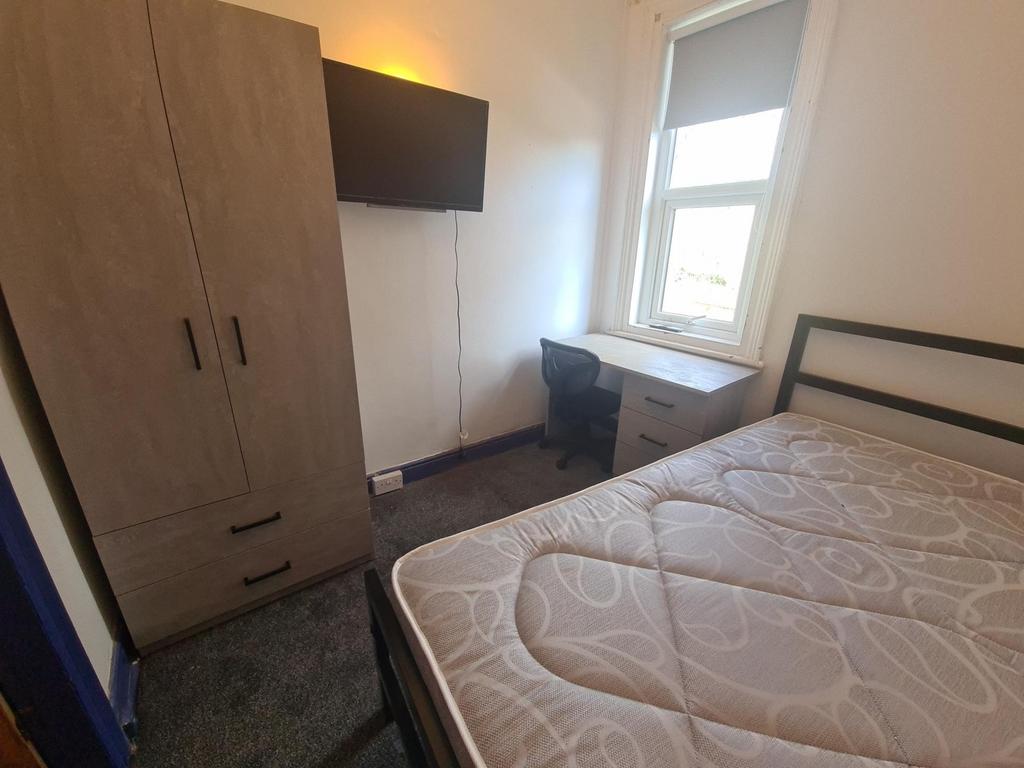 Bright, simply furnished bedroom with a comfort...