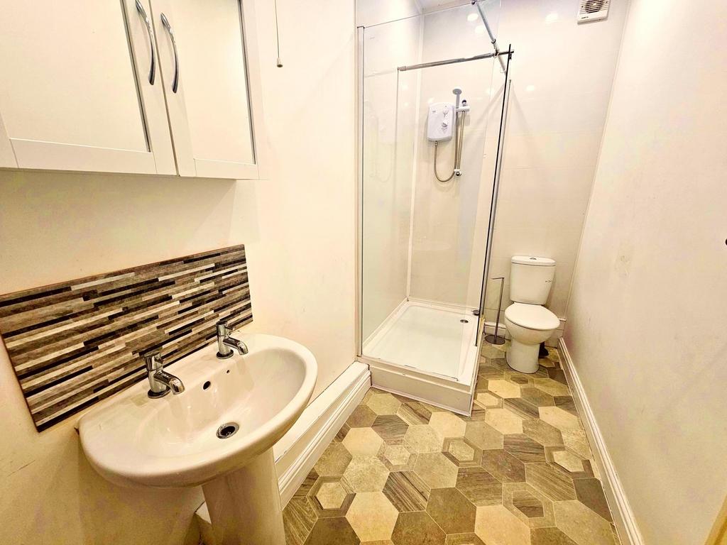 Bright, modern bathroom with a tiled shower enc...