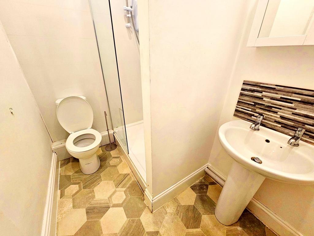 Compact, clean bathroom with a pedestal sink, t...