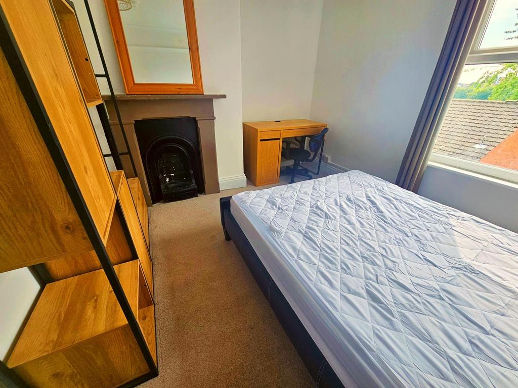Bright, well-kept bedroom with a large window, ...