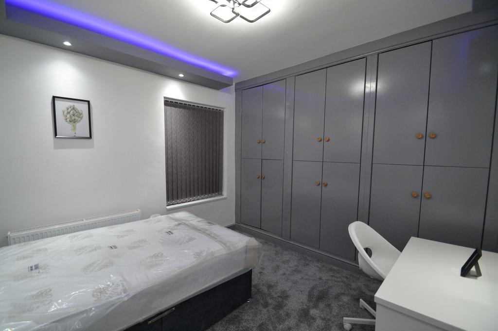 Modern double bedroom with built-in grey wardro...