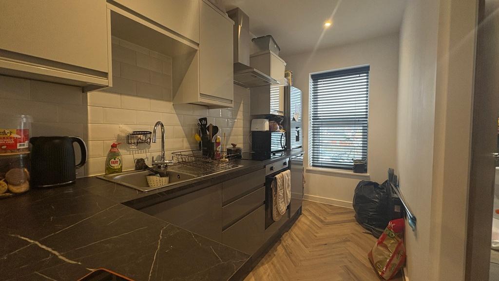 Modern galley kitchen with sleek dark cabinetry...