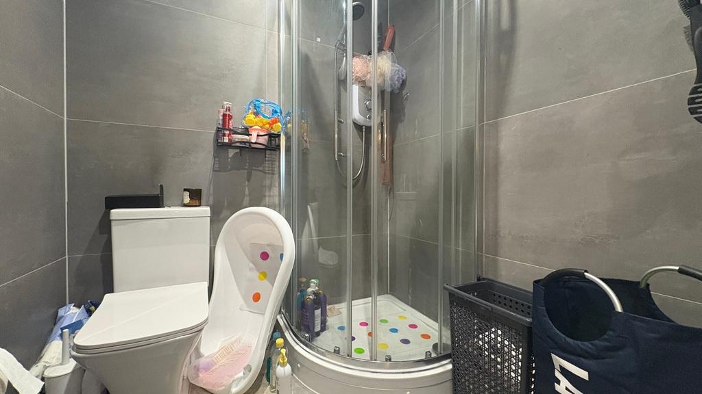 Contemporary tiled bathroom with a glass-enclos...
