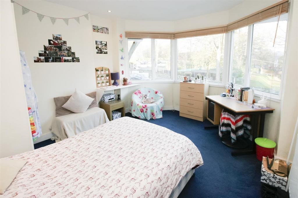 Cozy bedroom featuring a neatly made bed, a sma...