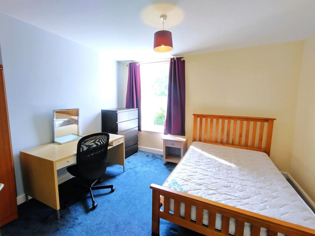 Bright, well-presented bedroom with a wooden do...