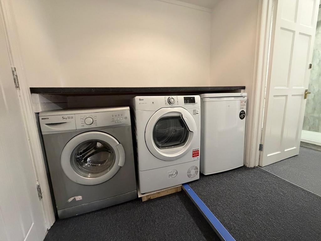 Neat utility area with a washing machine, tumbl...