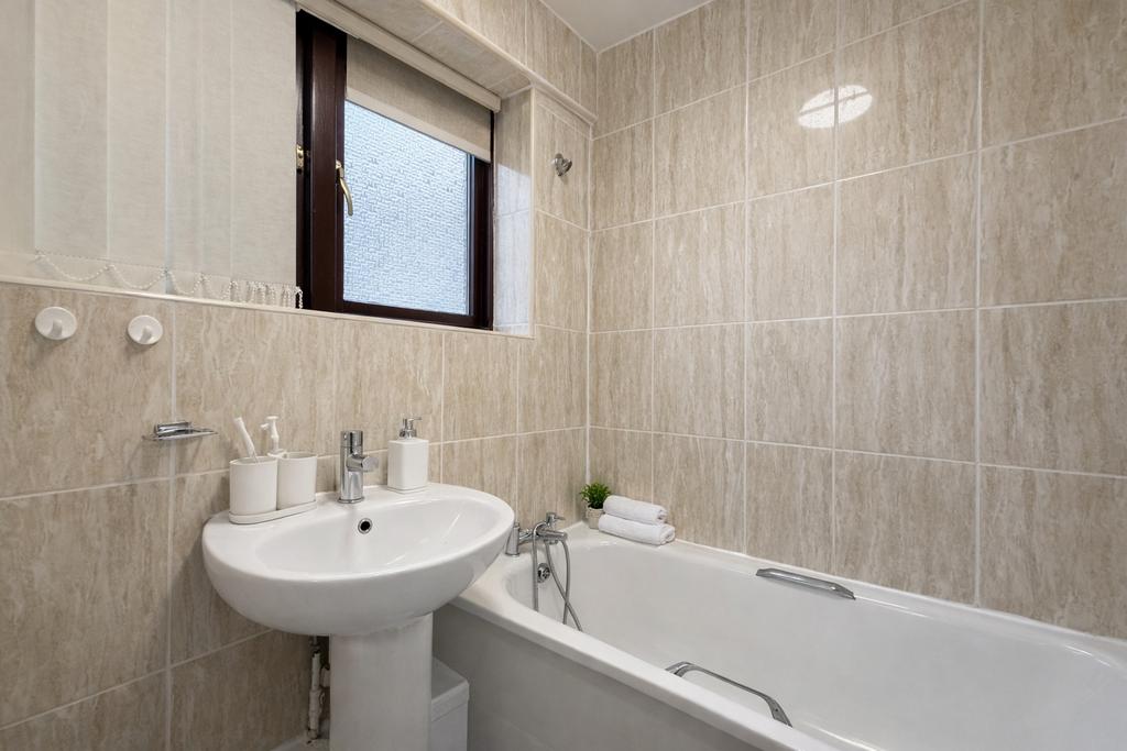 Bright, well-maintained bathroom with tiled wal...