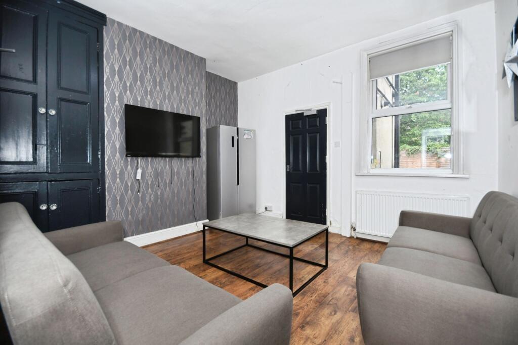 Contemporary shared lounge with paired sofas fa...