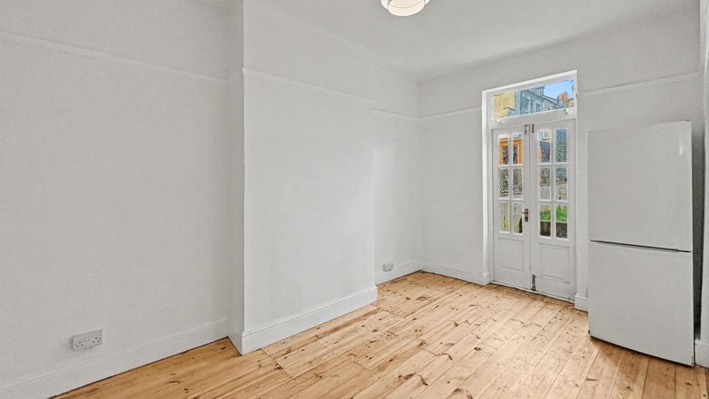 Bright, unfurnished kitchen space with wooden f...