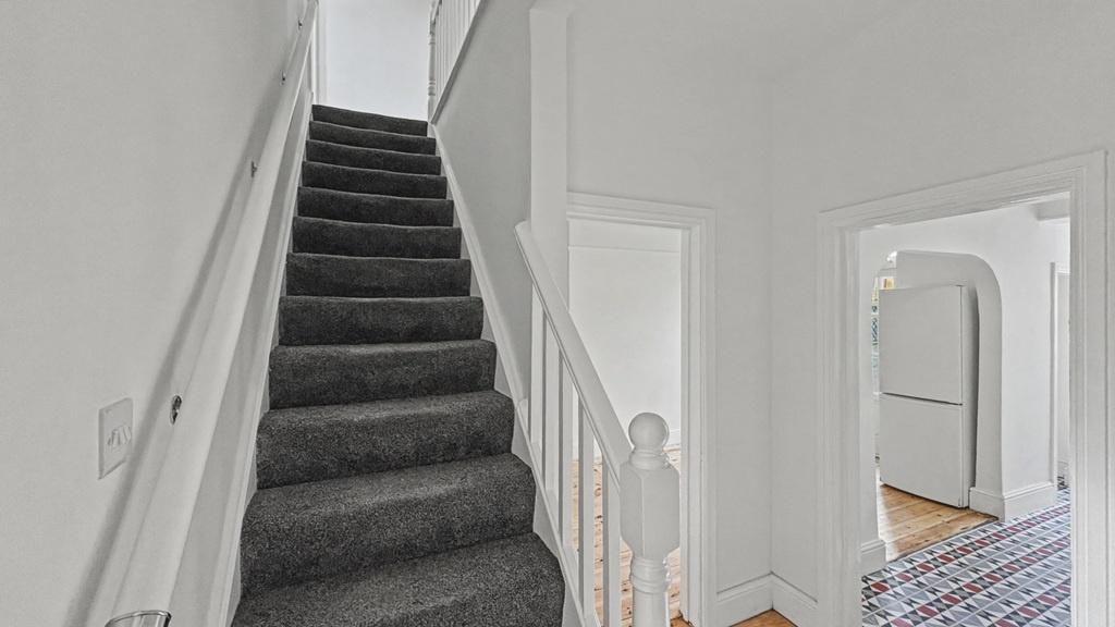 Bright, clean stairway with neutral decor and c...