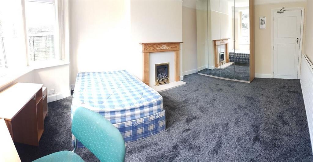 Bright, simply furnished bedroom with a double ...