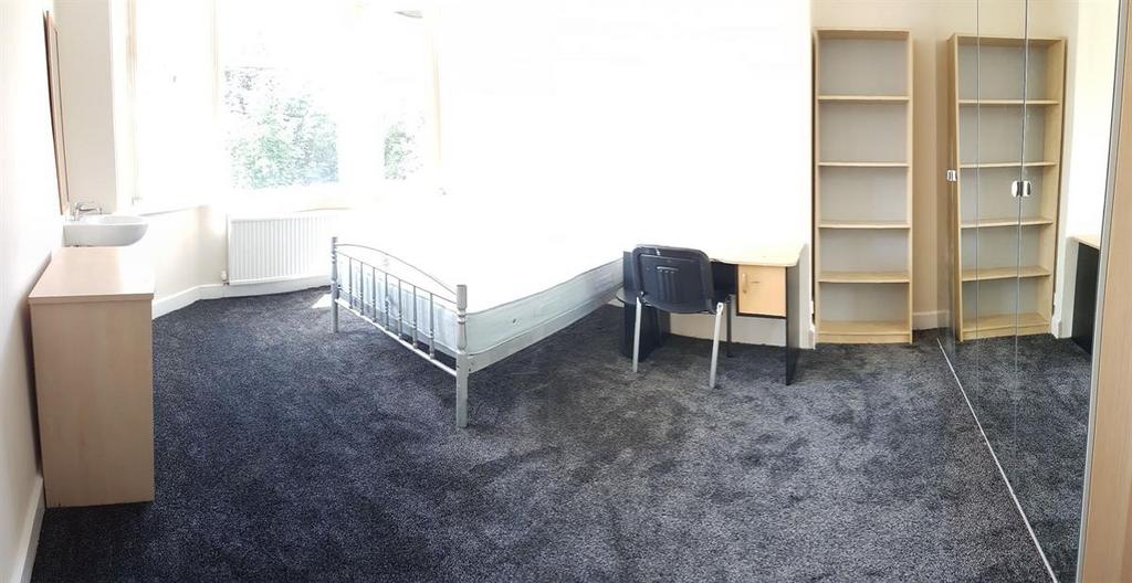 Bright, simply furnished bedroom with a large w...