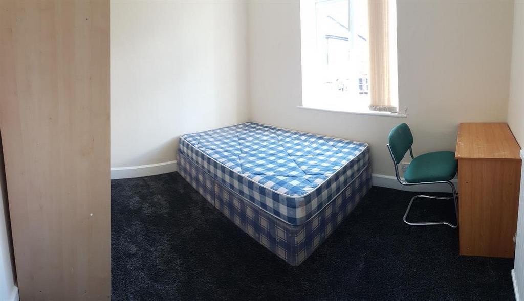 Bright, neutrally decorated bedroom with a sing...