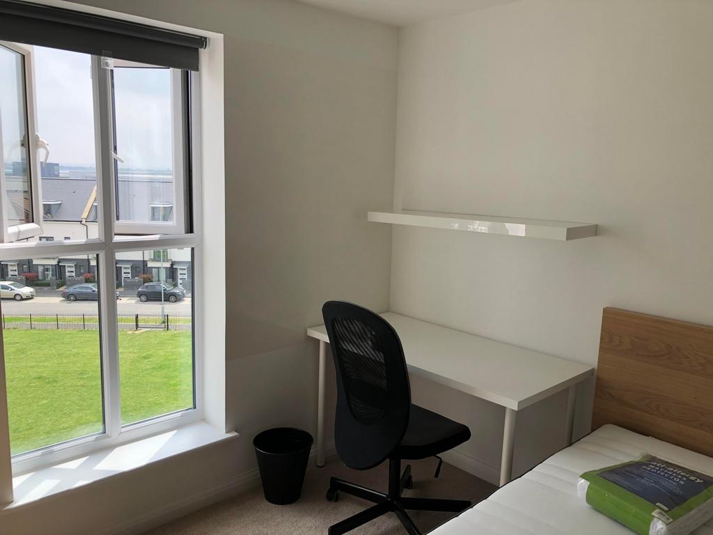A bright and inviting double bedroom with a des...