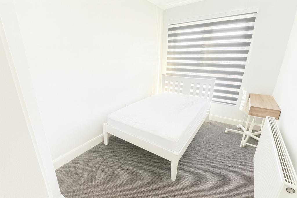 Bright and clean single bedroom featuring a com...