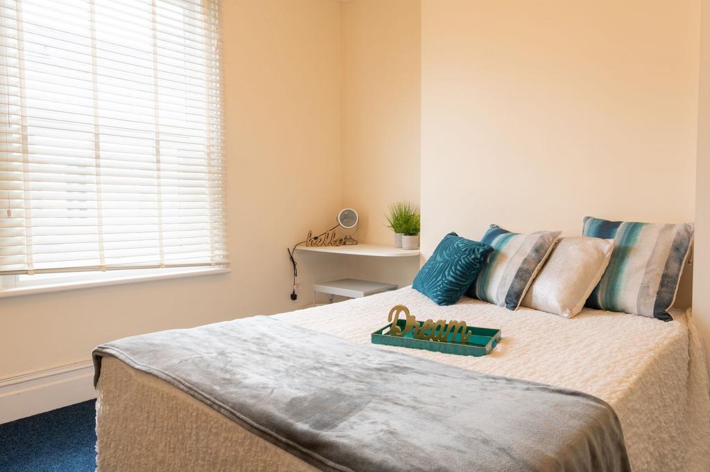 Bright, neatly styled bedroom with a comfortabl...