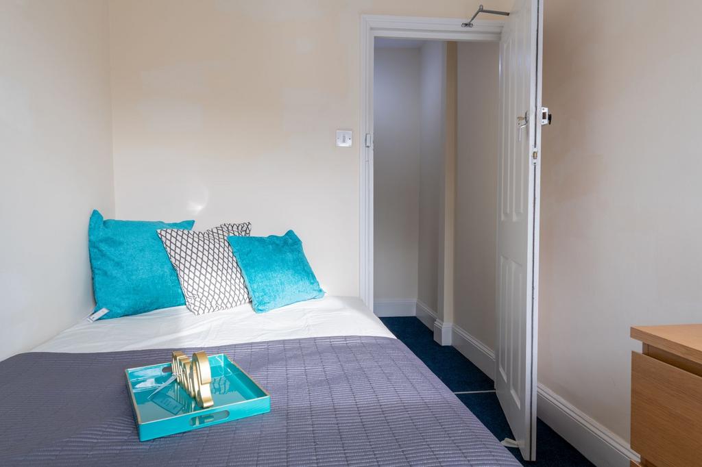 Bright, simply styled bedroom with a neatly mad...