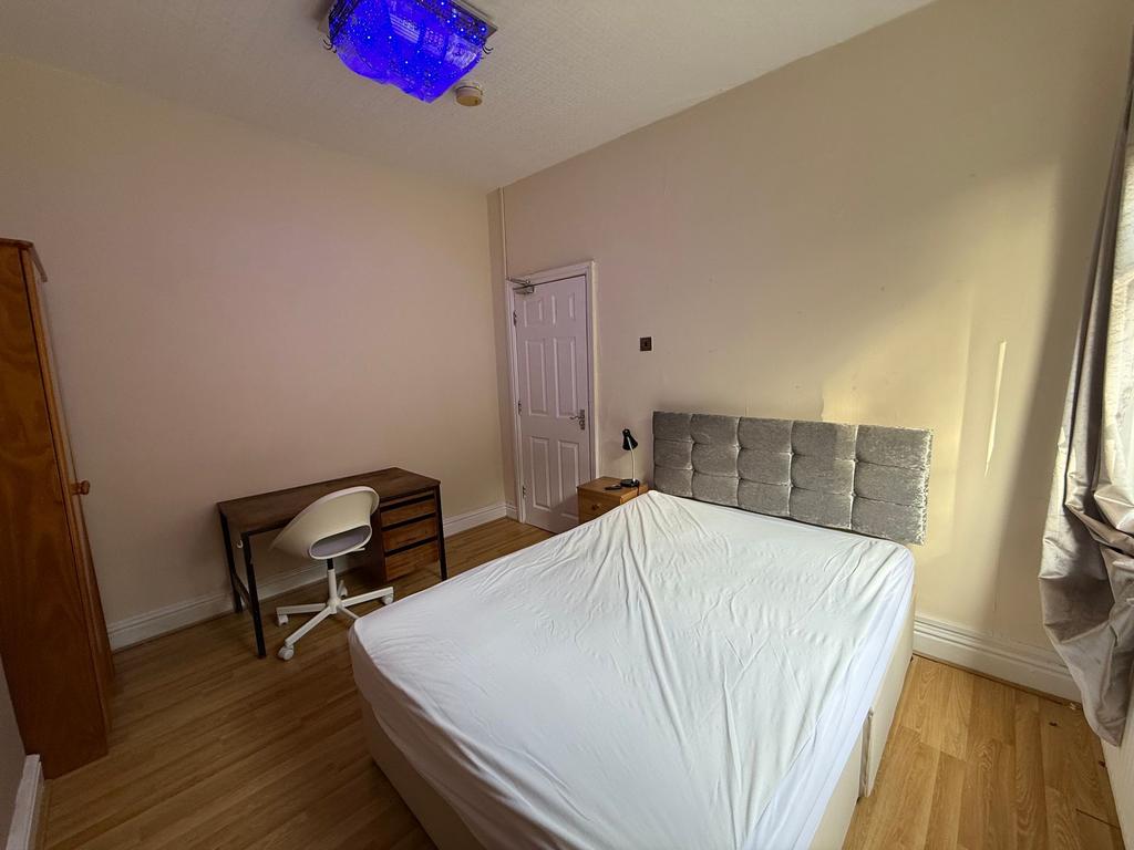 Bright, simply furnished double bedroom with a ...