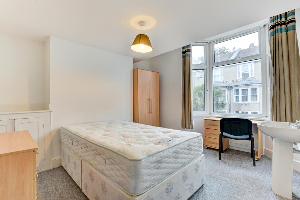 A spacious and bright master bedroom featuring ...
