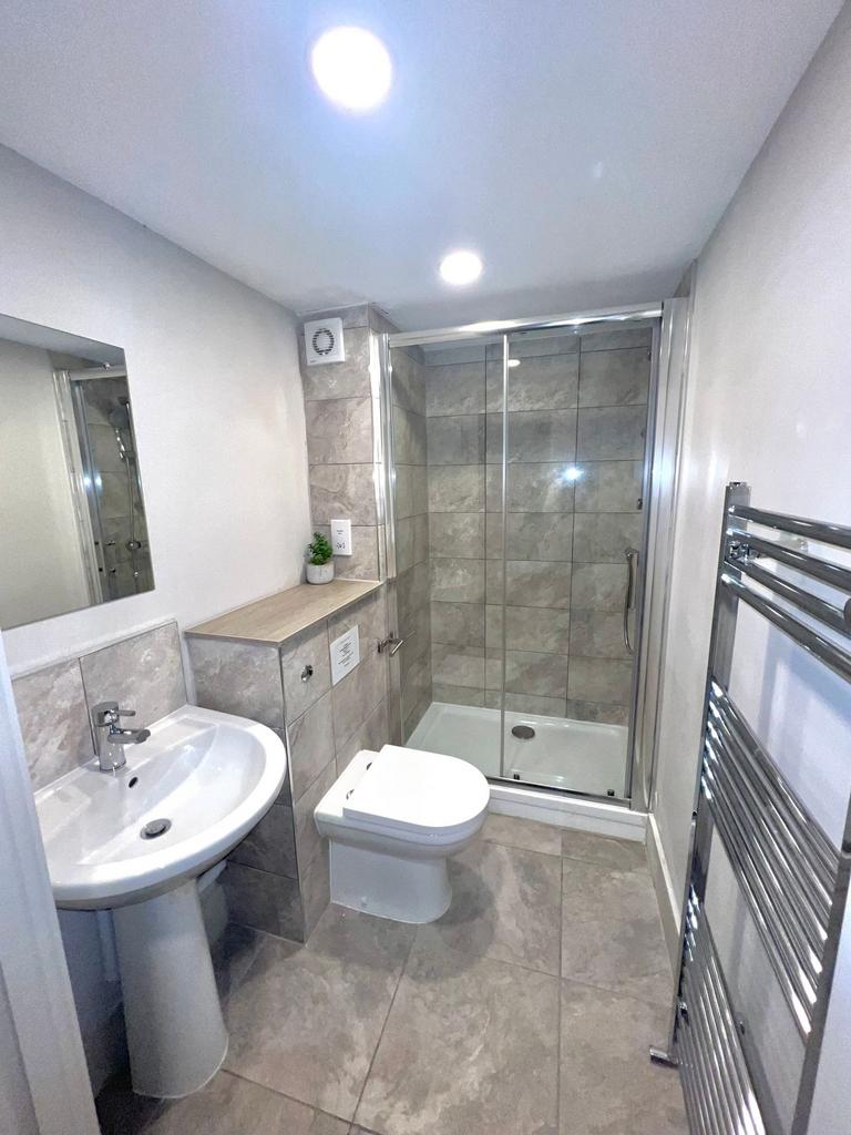 Modern tiled bathroom with a walk-in glass show...