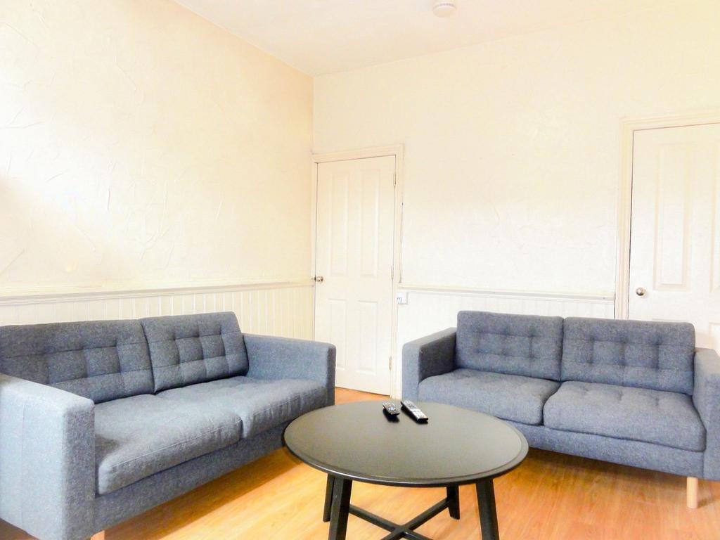 Bright, modern living room with two matching gr...