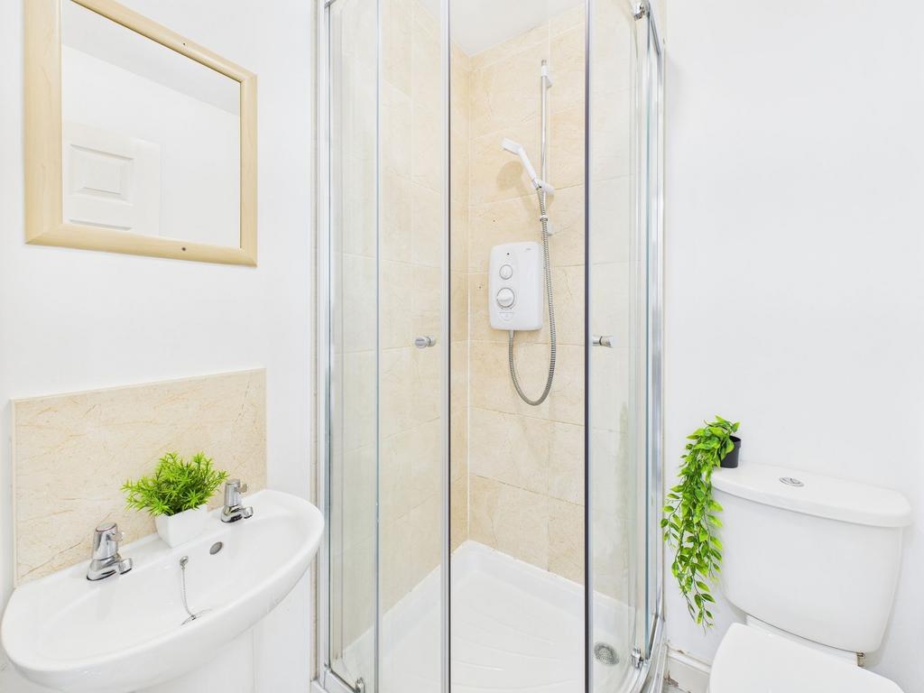 Bright, modern bathroom with a corner glass sho...