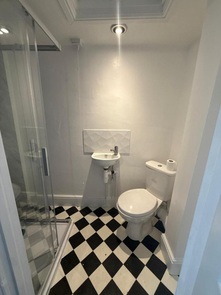 Compact, modern bathroom with a corner shower, ...
