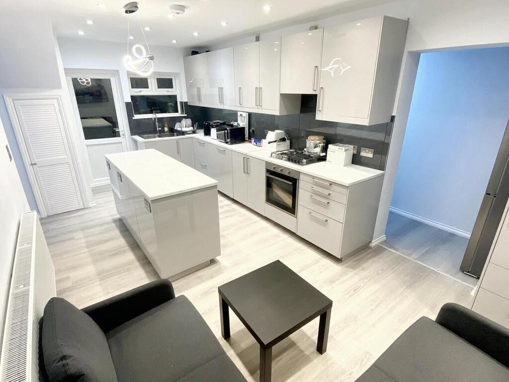 Bright modern galley kitchen with a central isl...