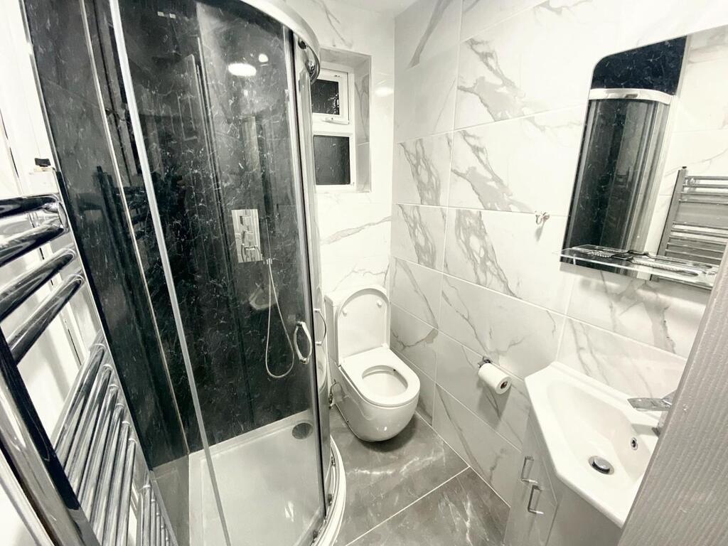 Modern bathroom with a curved glass shower encl...