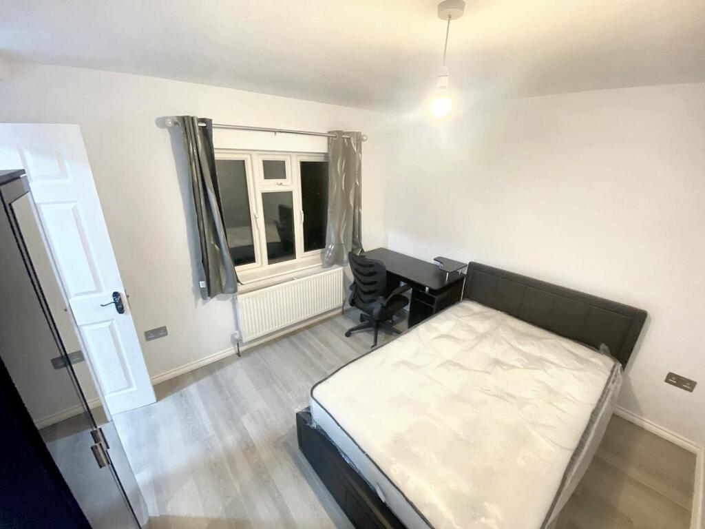 Bright, modern bedroom with a double bed, desk ...