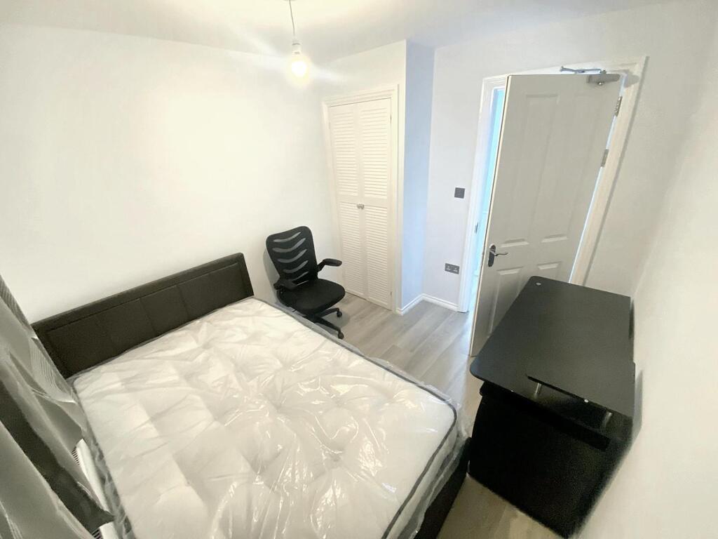 Bright, simply furnished bedroom with a comfort...