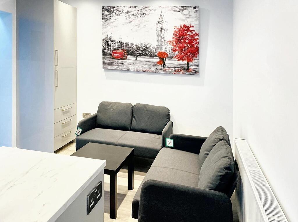 Bright, modern living area with matching grey s...