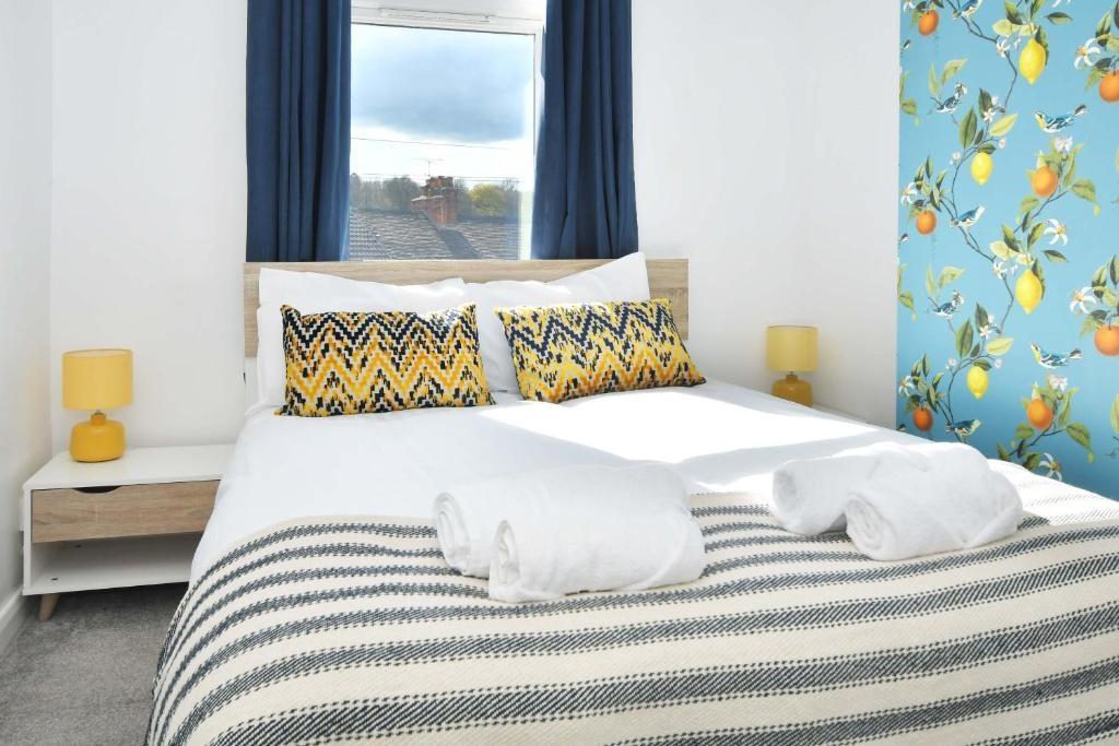 Bright double bedroom with a neatly made bed, p...