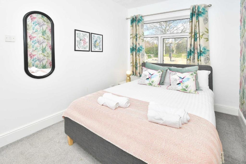 Bright double bedroom with a neatly made bed, p...