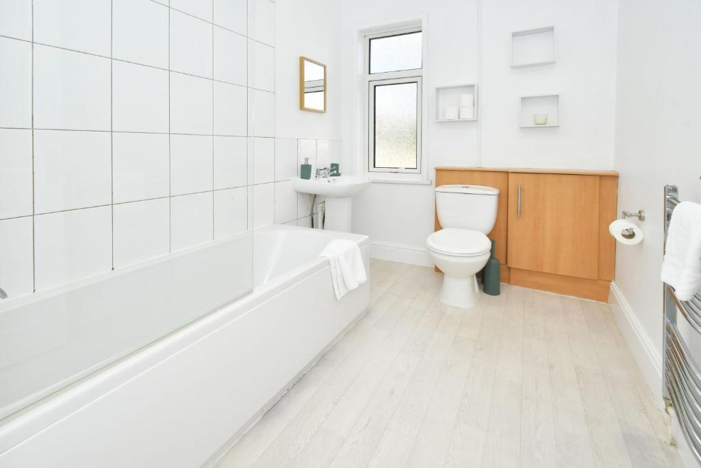 Bright, modern bathroom with a full-size bath a...