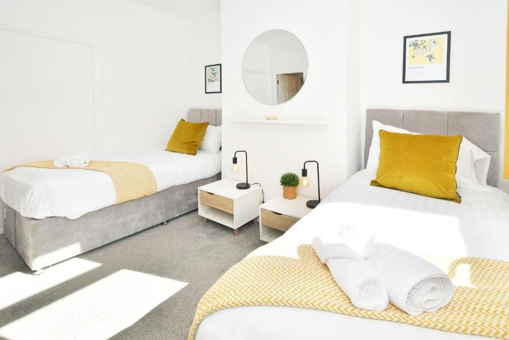 Bright, modern twin bedroom with two neatly mad...