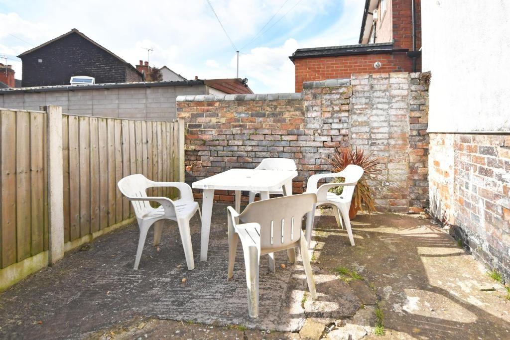 Sunny enclosed rear patio with a brick boundary...