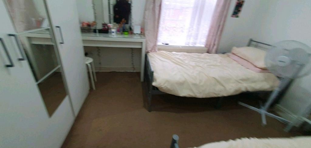 Bright, simply furnished bedroom with two beds,...