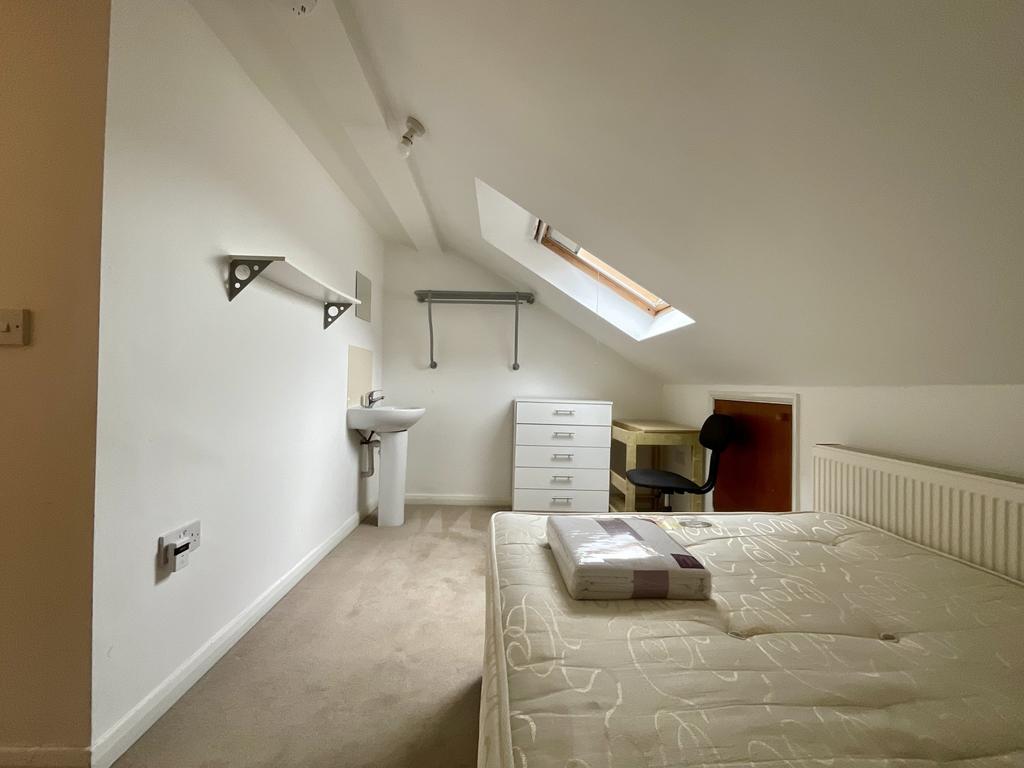 Bright attic-style bedroom with a sloped ceilin...