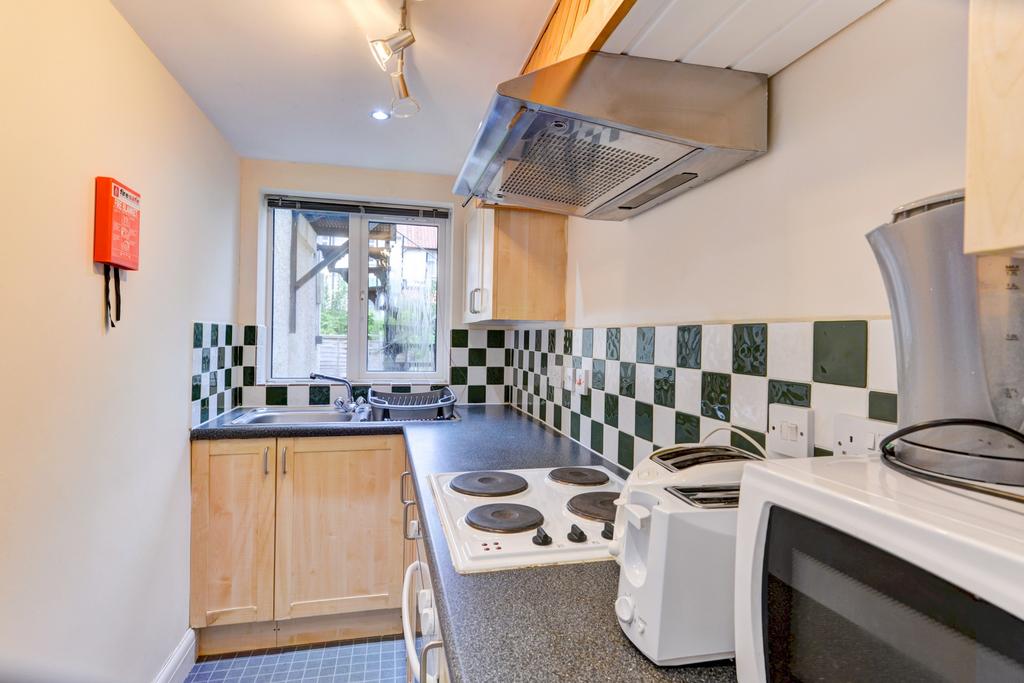 A bright and clean kitchen with a window allowi...