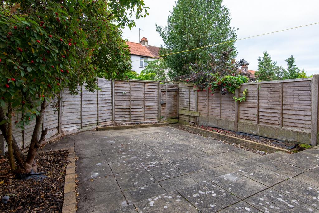 Private paved garden with mature trees and surr...