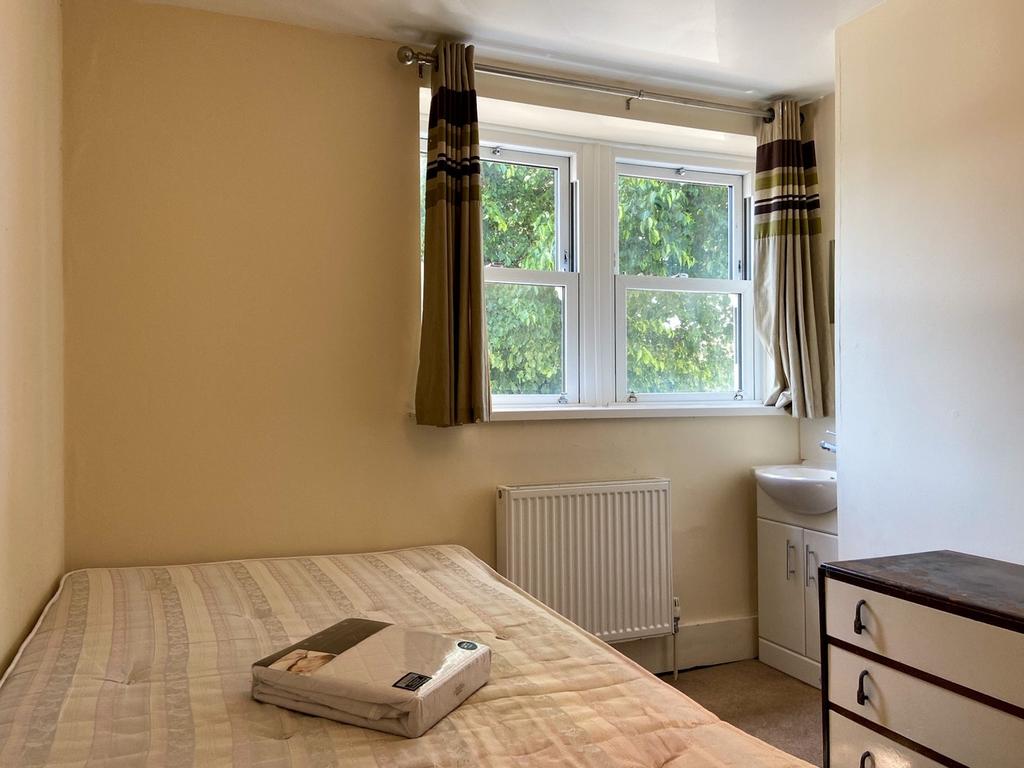 A cozy bedroom featuring a double bed with a be...
