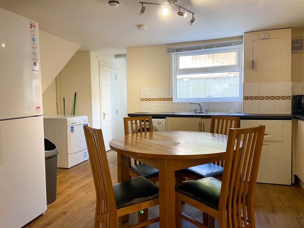 Bright, well-kept kitchen with a central wooden...