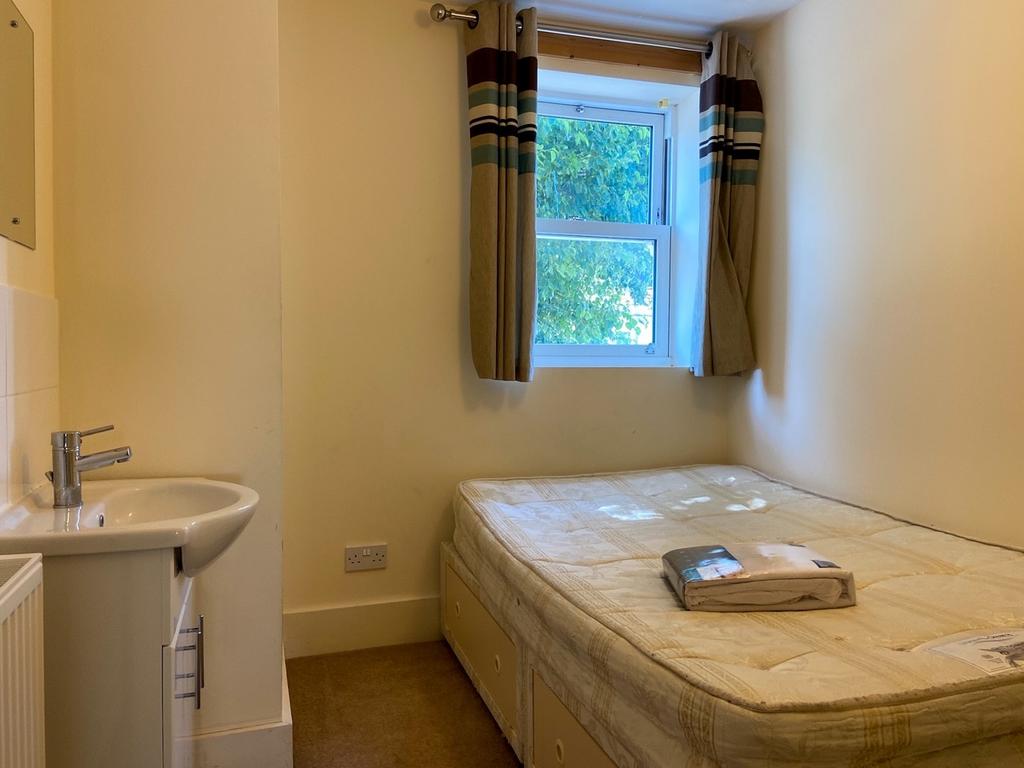 Compact bedroom with a fitted single bed beside...