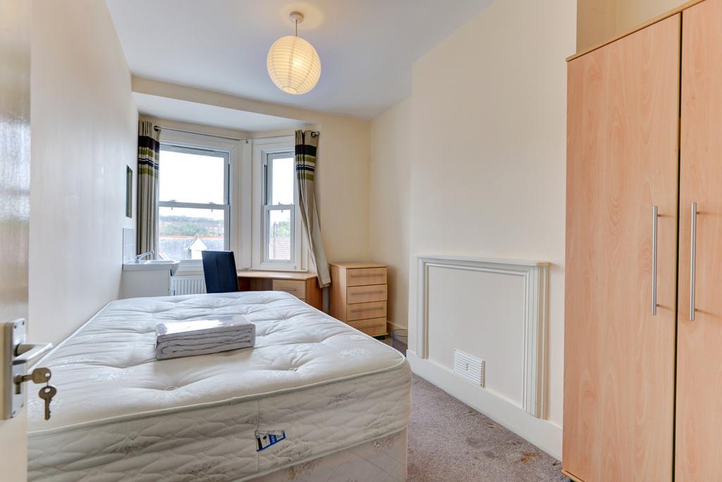 A bright and inviting master bedroom with a lar...