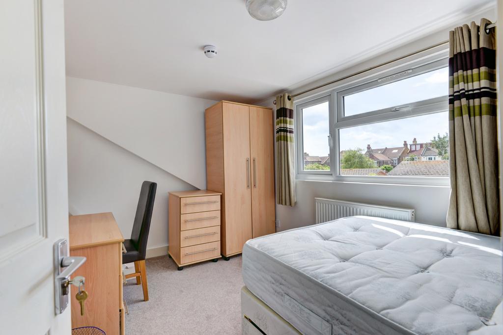 A bright and tidy single bedroom featuring a la...