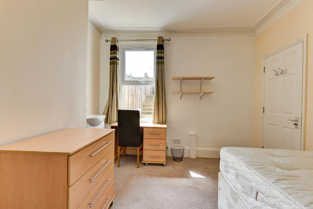 Bright, simply furnished bedroom with a large w...