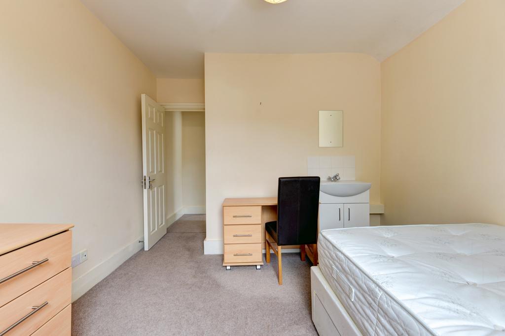 A neat and simple bedroom featuring a large bed...