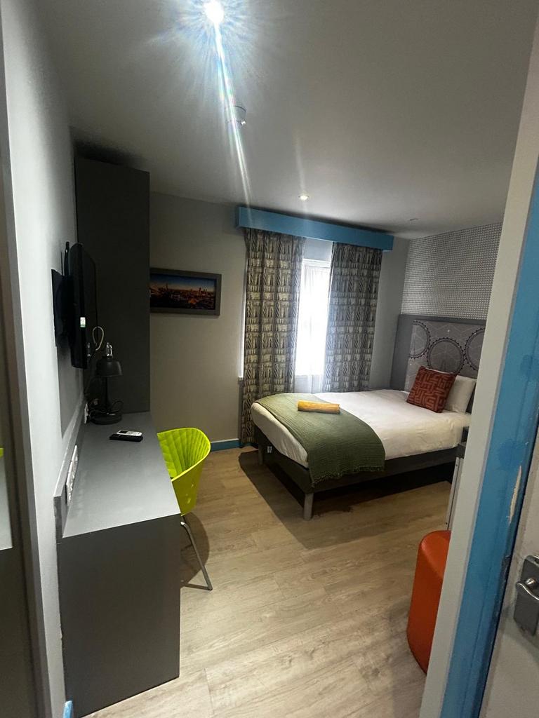 Bright, modern double bedroom with a neatly mad...