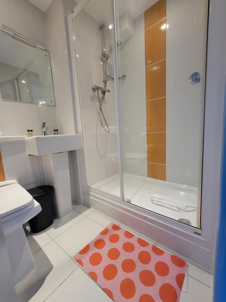 Bright, modern bathroom with a walk-in shower f...